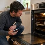 Homeowner checking an oven thermometer while calibrating oven temperature