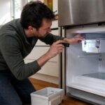 Homeowner inspecting an ice maker inside an open freezer